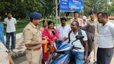 बोकारो में हेलमेट पहनने वाले वाहन चालक को गुलाब देते पुलिस अधिकारी