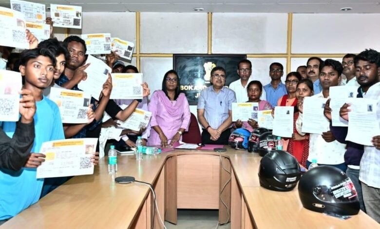 उपायुक्त अजय नाथ झा बोकारो में चालकों को ड्राइविंग लाइसेंस और हेल्मेट वितरित करते हुए