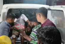 निरसा में पुलिस मुठभेड़ के बाद घायल कथित शूटर को अस्पताल ले जाती पुलिस